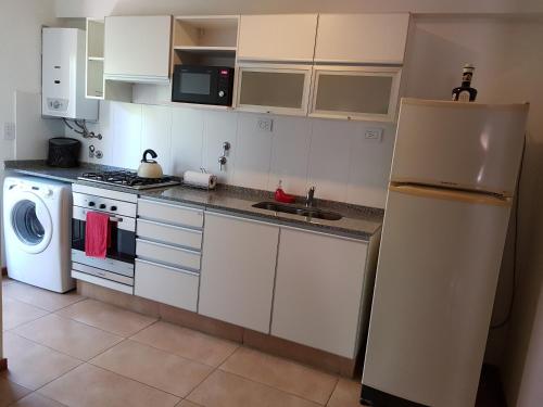 a kitchen with a refrigerator and a washer and dryer at Plaza López in Rosario