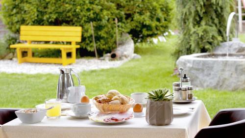 a white table with a basket of food on it at Pension Sattlerenglhof in Laces