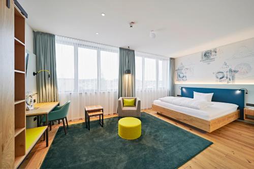 a hotel room with a bed and a desk at Hotel Federwerk in Sankt Georgen im Schwarzwald