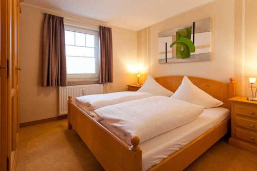 a bedroom with a large bed with a window at Ferienwohnung mit Balkon im Ostsee in Binz