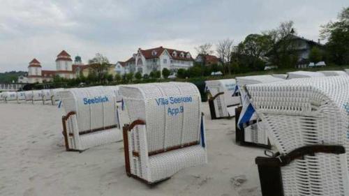 a row of beach chairs in the sand on a beach at Ferienwohnung mit Balkon im Ostsee in Binz