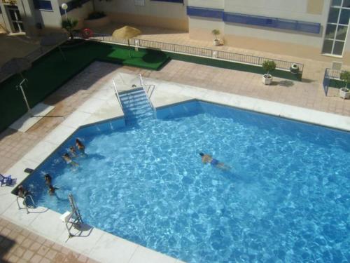 un grupo de personas nadando en una gran piscina en AMPLIO Y AGRADABLE APARTAMENTO WIFI GRATIS en Torrox Costa