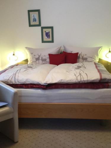 a bedroom with a large bed with red pillows at Haus Frainer in Wald am Arlberg