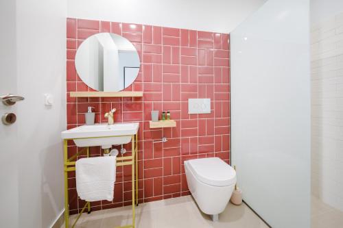 ein Badezimmer mit einem WC, einem Waschbecken und einem Spiegel in der Unterkunft Stylish Studio Apartment - 1 House in Kalamata