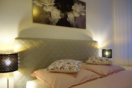1 dormitorio con 1 cama con 2 almohadas y 2 lámparas en Nettes, gemütliches Apartment en Wuppertal