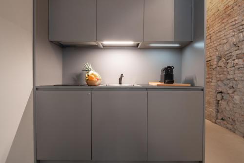 a kitchen with a sink and a fruit on the counter at OFFICINE CAVOUR Piazza Cavour in Padova