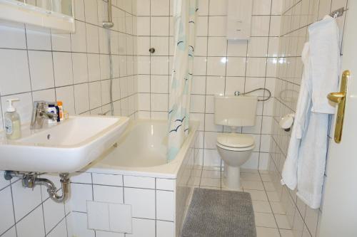 a white bathroom with a sink and a toilet at Nettes, gemütliches Apartment in Wuppertal