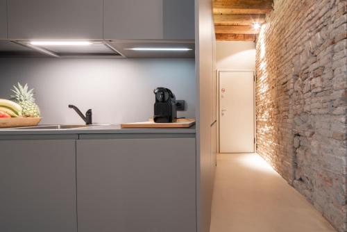 a kitchen with a counter and a brick wall at OFFICINE CAVOUR Piazza Cavour in Padova