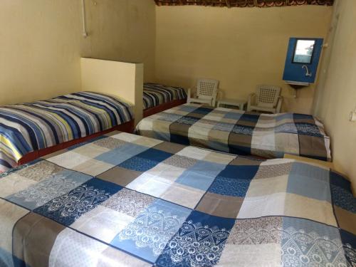 a room with two beds and two chairs at Sítio Santa Cecília in Ubajara