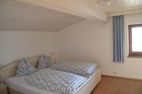 a bedroom with a bed with blue pillows on it at Gästehaus Garber in Stumm