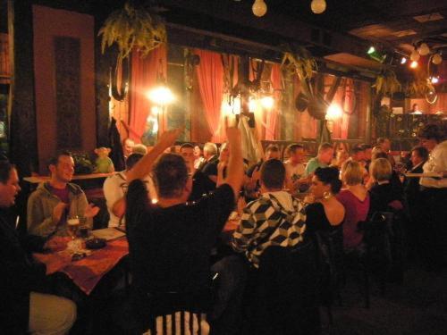 a group of people sitting in a room with their hands up at Hotel 4 Hufen in Großziethen