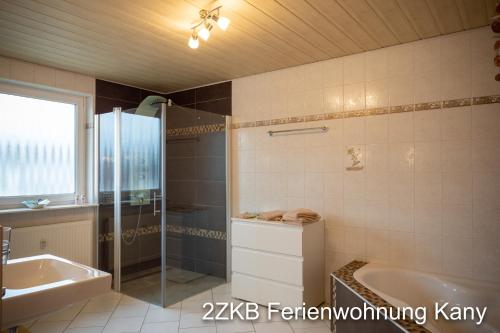 bagno con vasca, doccia e lavandino di Ferienwohnung Kany a Bliesmengen-Bolchen