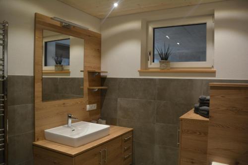 uma casa de banho com um lavatório e um espelho em Apart Geiger em Arzl im Pitztal