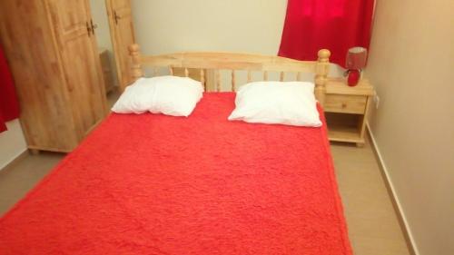 a bedroom with a bed with a red blanket at Gites Man-non in Sainte-Anne