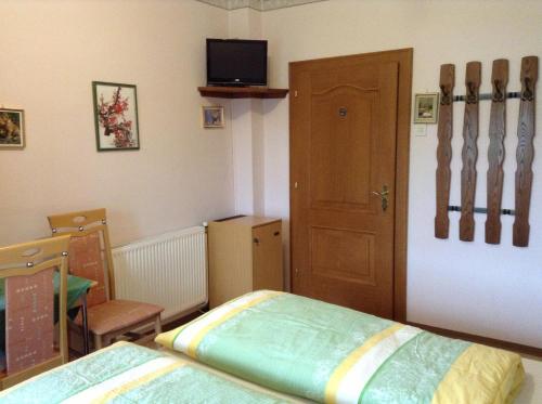 a bedroom with a bed and a door with a tv at Gästehaus Renate in Velden am Wörthersee