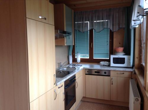 a small kitchen with a sink and a microwave at Gästehaus Renate in Velden am Wörthersee