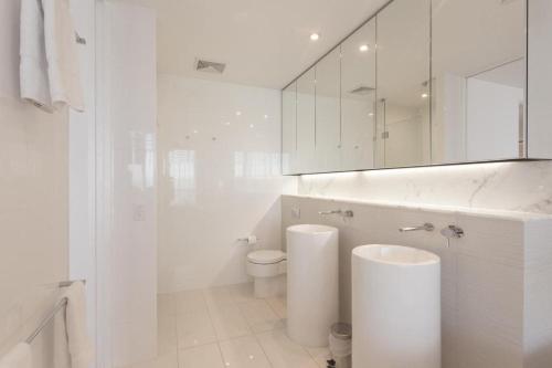 a white bathroom with a toilet and a mirror at Luxury 3 Bedroom in heart of Broadbeach in Gold Coast