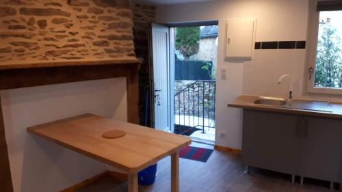 a kitchen with a wooden table and a sink at Chez Papy et Mamie in Aubazines