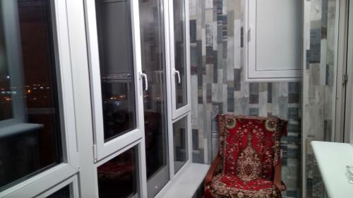 a red chair sitting in a room with windows at Apartment Danchehko 3b in Chornomorsk