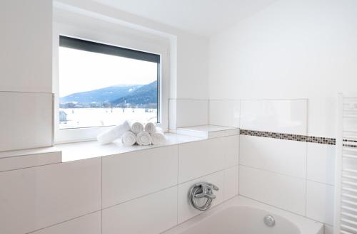 a white bathroom with a window and a tub at Appartements-Dalila in Sankt Michael im Lungau