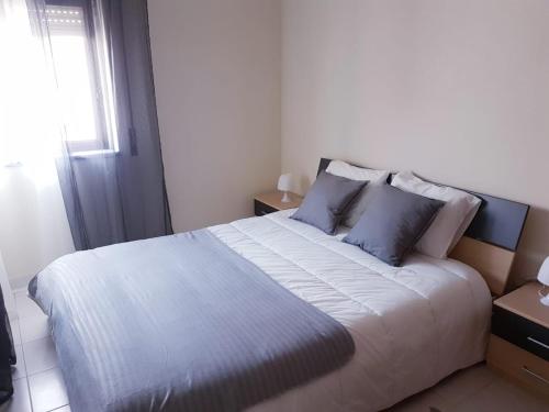 ペニシェにあるPeniche holiday homeのベッドルーム(青い枕の大きな白いベッド付)