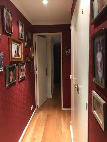 a hallway with a red wall with pictures on it at Avenida Las Heraas in Buenos Aires