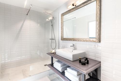 a white bathroom with a sink and a mirror at Résidences Alticimes in Brides-les-Bains