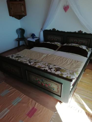 a bedroom with a large bed with a wooden floor at Haus Homann in Sulzberg