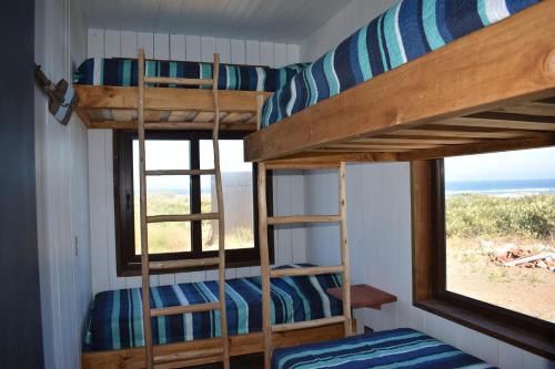 two bunk beds in a room with a window at Morros del Pacífico in Pichilemu