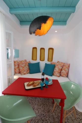 a living room with a red table and a couch at Naxos Cave Suites in Stelida