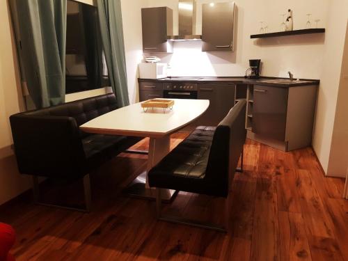una pequeña cocina con mesa y sillas en una habitación en Winterbergappartments en Winterberg