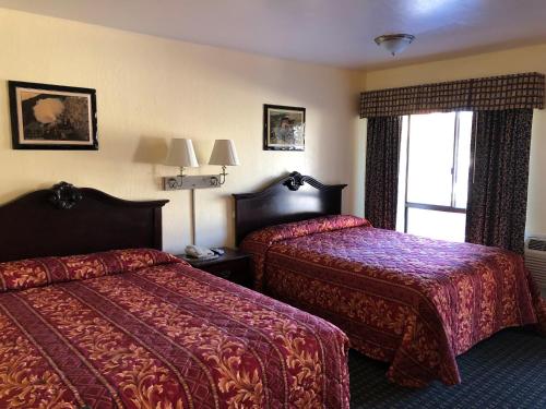 a hotel room with two beds and a window at Jamestown Railtown Motel in Jamestown