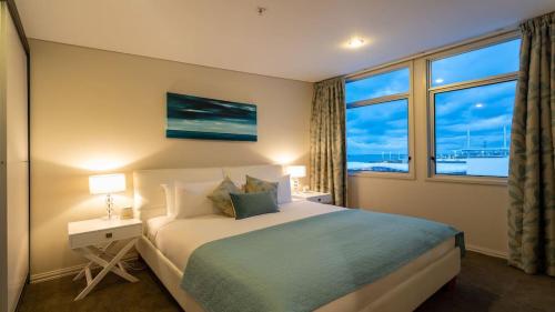 Habitación de hotel con cama y ventana en Princes Wharf's truly stunning North-West Loft, en Auckland