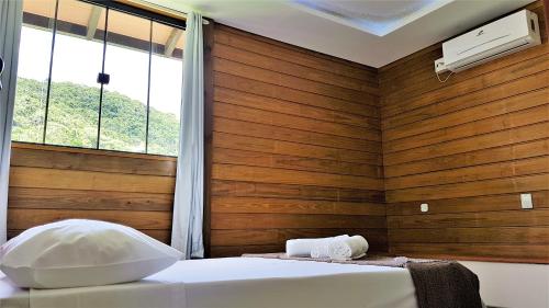 Habitación con 2 camas y pared de madera. en Del Sol 2, en Bombinhas