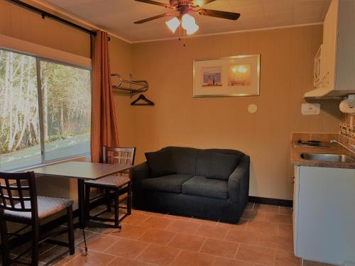 a living room with a couch and a table at Malahat Bungalows Motel in Malahat