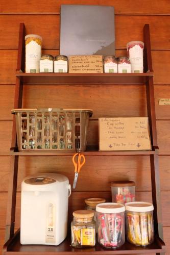 a shelf with a toaster and other items on it at Ashi Guesthouse Chiangdao in Chiang Dao