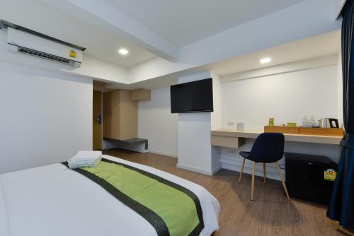 a bedroom with a bed and a desk and a chair at iCheck inn Sukhumvit 19 in Bangkok