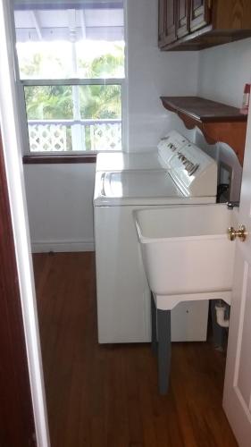 a kitchen with a white sink and a window at Hawaii Tropical Volcano mansion + Sauna in Hilo