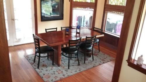 a dining room with a wooden table and chairs at Hawaii Tropical Volcano mansion + Sauna in Hilo