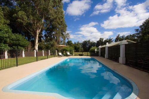 a large blue swimming pool in a yard at Mudgee Country Grandeur at this Elegant Group Getaway in Mudgee