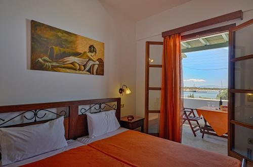 a bedroom with a bed and a view of the ocean at Margaritis Apartments in Agia Anna Naxos