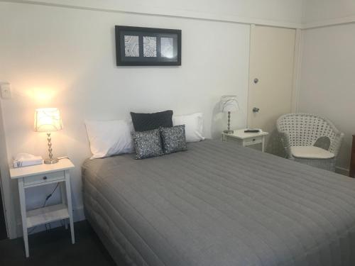 a bedroom with a bed and a lamp and a chair at Marlo Hotel in Marlo