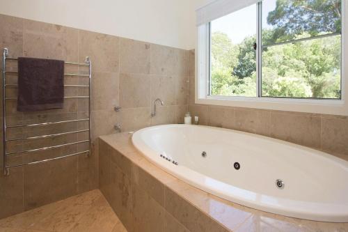 a large bathroom with a tub and a window at Mudgee Country Grandeur at this Elegant Group Getaway in Mudgee