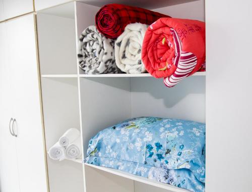 a white closet with a shelf filled with clothes at Kasato Maru Residence in Florianópolis