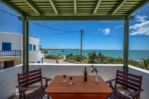 a table and chairs on a balcony with a view of the ocean at Margaritis Apartments in Agia Anna Naxos