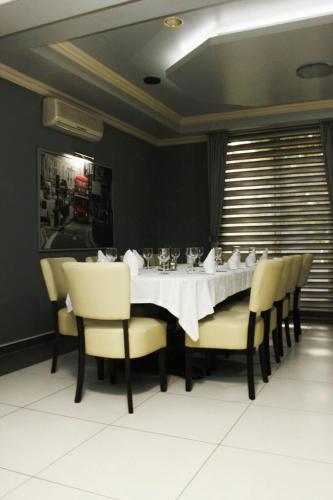a dining room with a white table and chairs at Motel Magistrala in Doboj