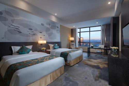 a hotel room with two beds and a desk at Shenyang Huaqiang Novlion Hotel in Daoyi