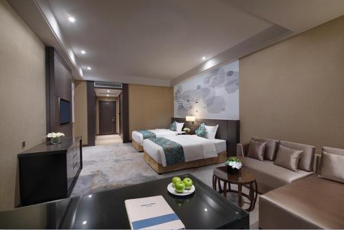 a hotel room with a bed and a couch at Shenyang Huaqiang Novlion Hotel in Daoyi