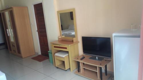 a room with a tv and a dresser at Jomtien Hostel in Jomtien Beach