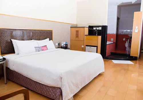 a bedroom with a large white bed in a room at Royal Group Motel Chien Kuo Branch in Kaohsiung